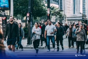 Pedestrians crossing a busy city street illustrating urban life and population growth